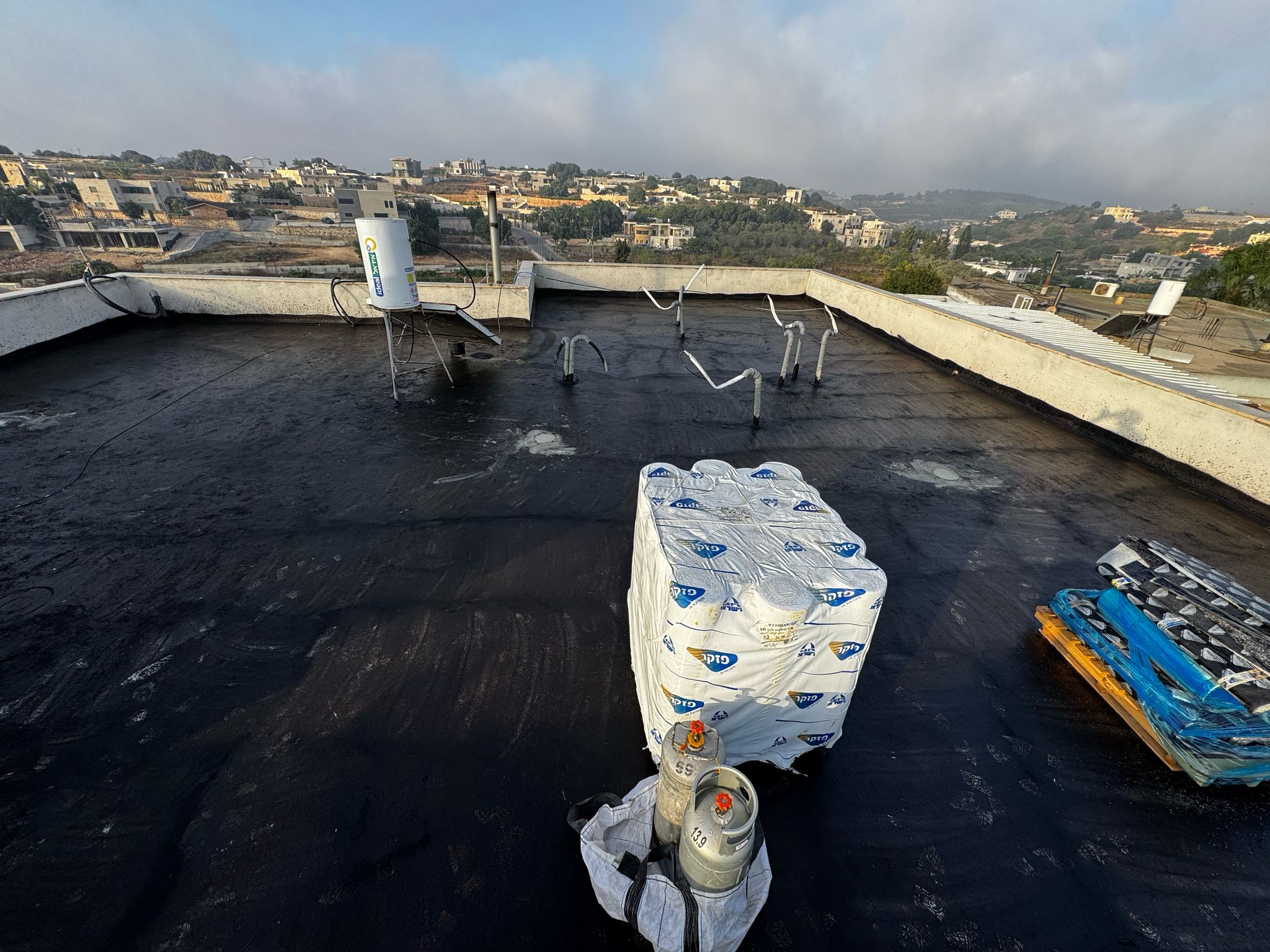 איטום גגות בעוספיה – תיקון שיפועים ואיטום מקצועי עם יריעות ביטומניות 3 מריחת פריימר על גג בעוספיה לקראת הנחת יריעות ביטומניות