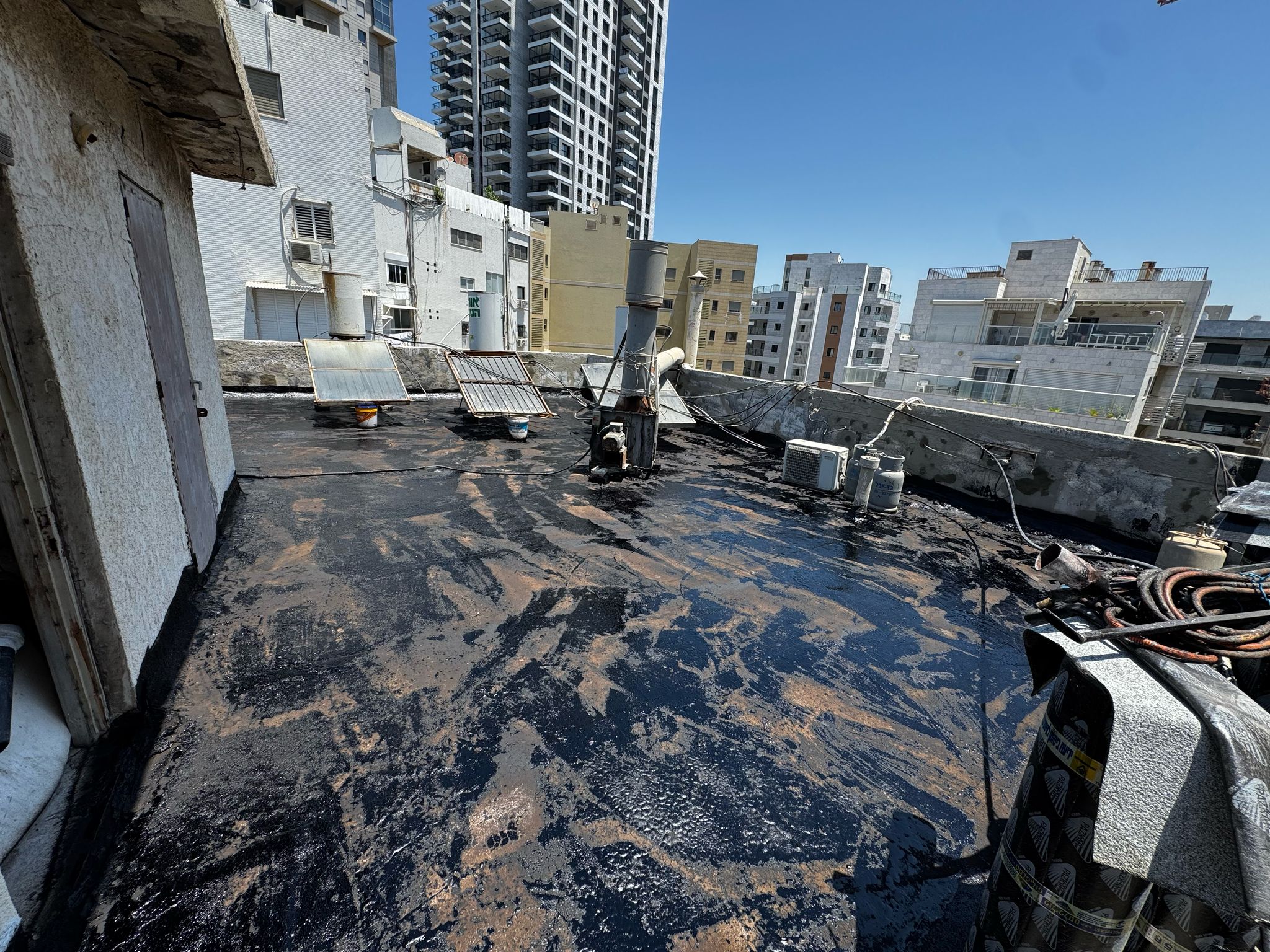 איטום גגות בבת ים – פרויקט מלא משלב ההכנה ועד התוצאה הסופית 4 איטום גגות בבת ים – מריחת פריימר ביטומני שחור כהכנה ליריעות