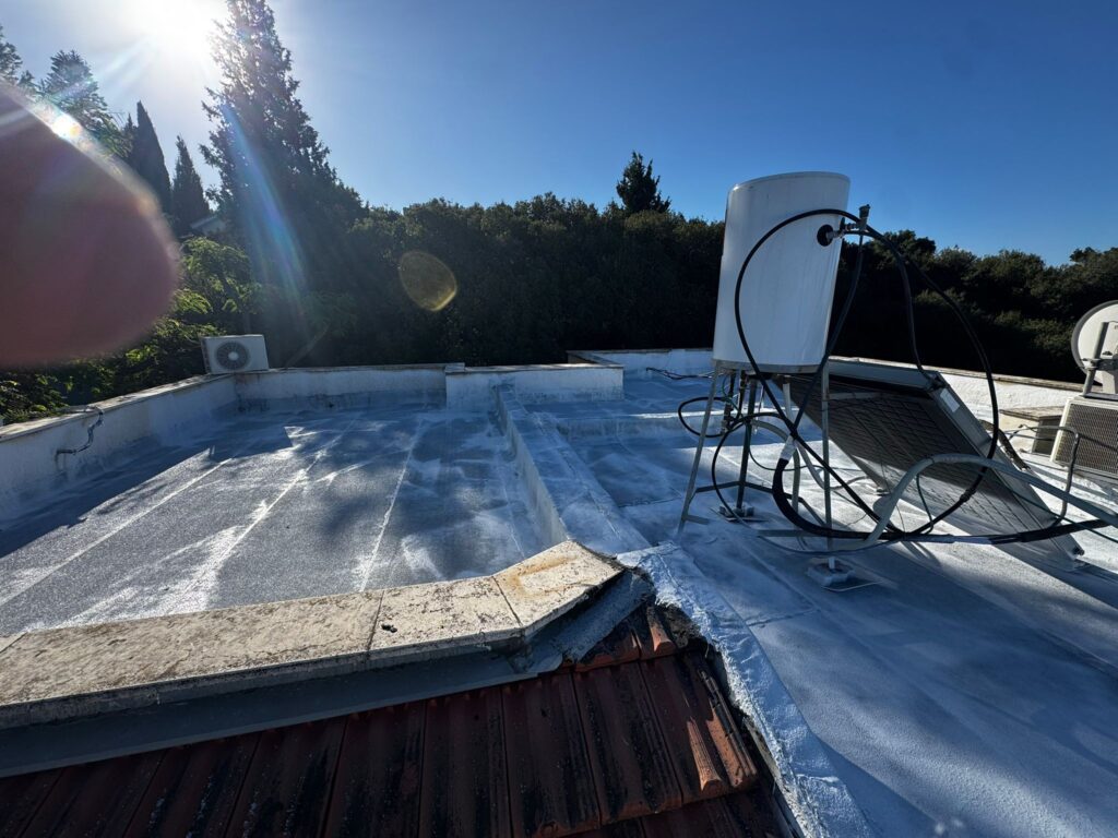 איטום גגות בתמרת – שכבה ראשונה רטובה של אקריל פז על גבי היריעות הביטומניות