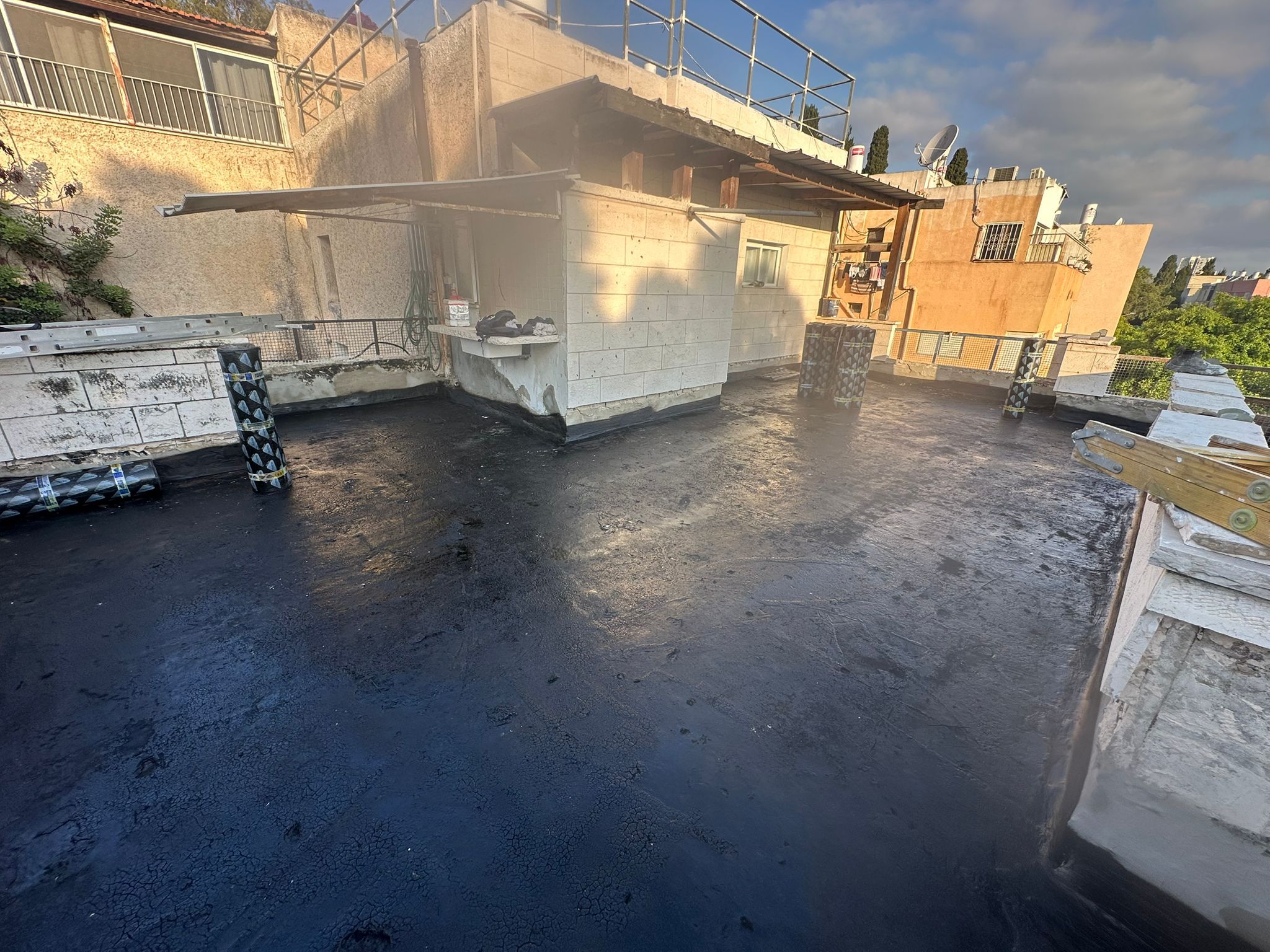 איטום מרפסת בחיפה – פריימר ביטומני שחור טרי לפני התחלת עבודת יריעות ביטומניות