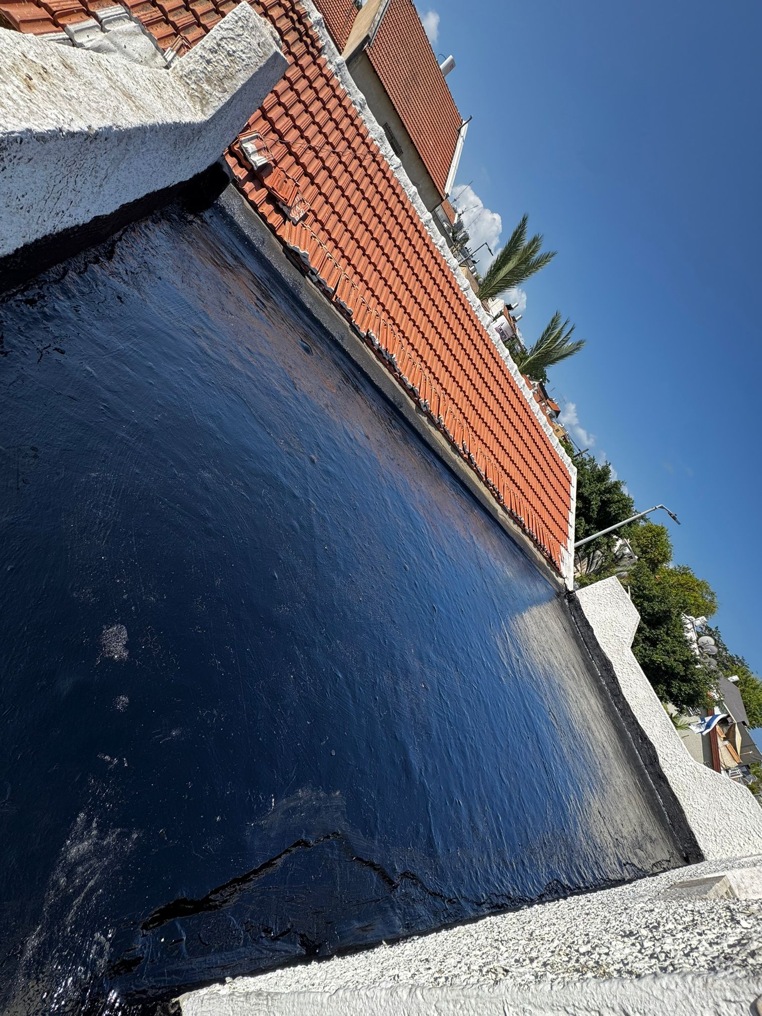 יישום שכבת איטום ביטומני שחורה על גג בחולון – רחוב יפו 25