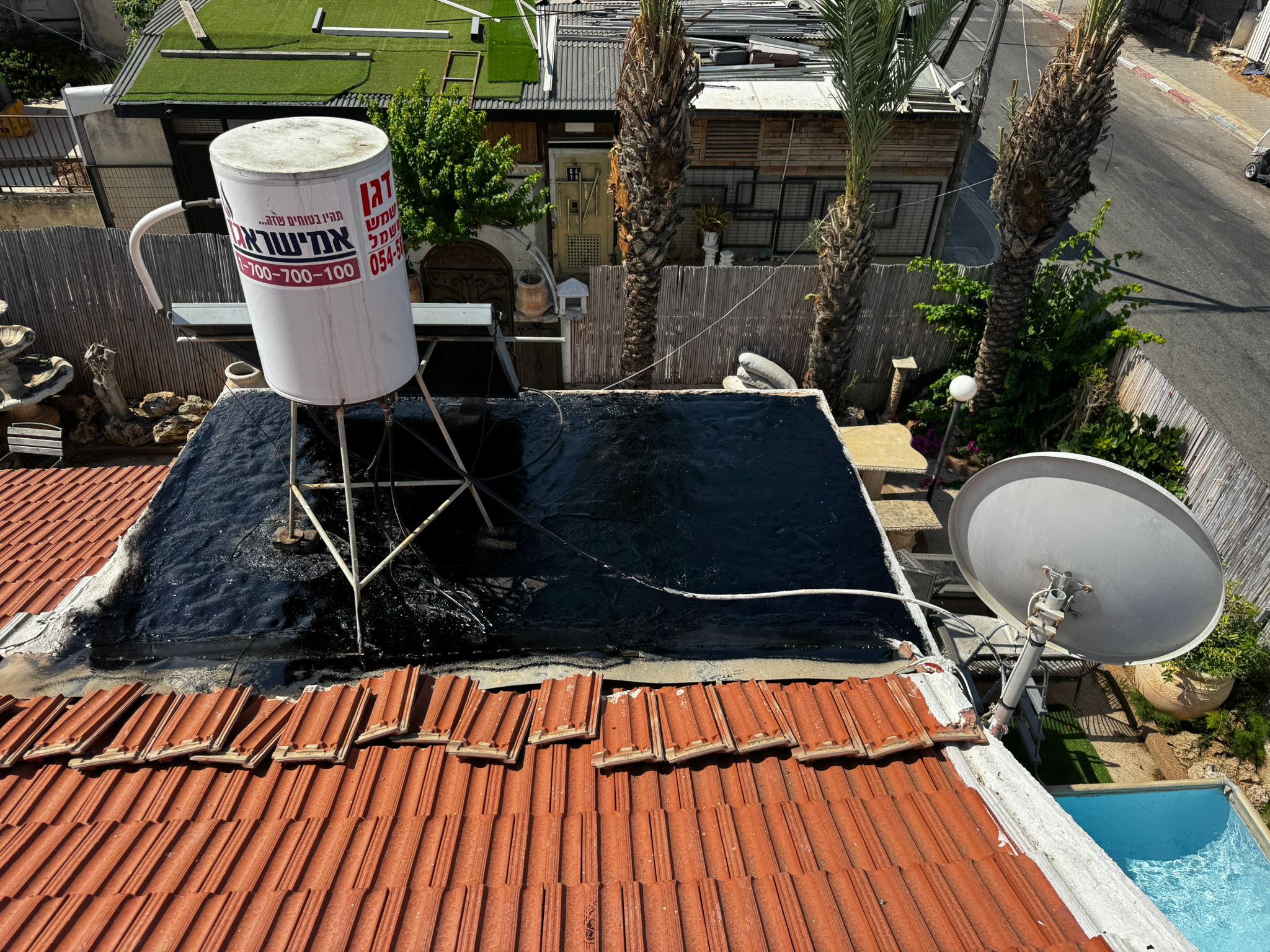 שכבת איטום ביטומני שחורה סביב בסיס דוד שמש בחולון – רחוב יפו 25