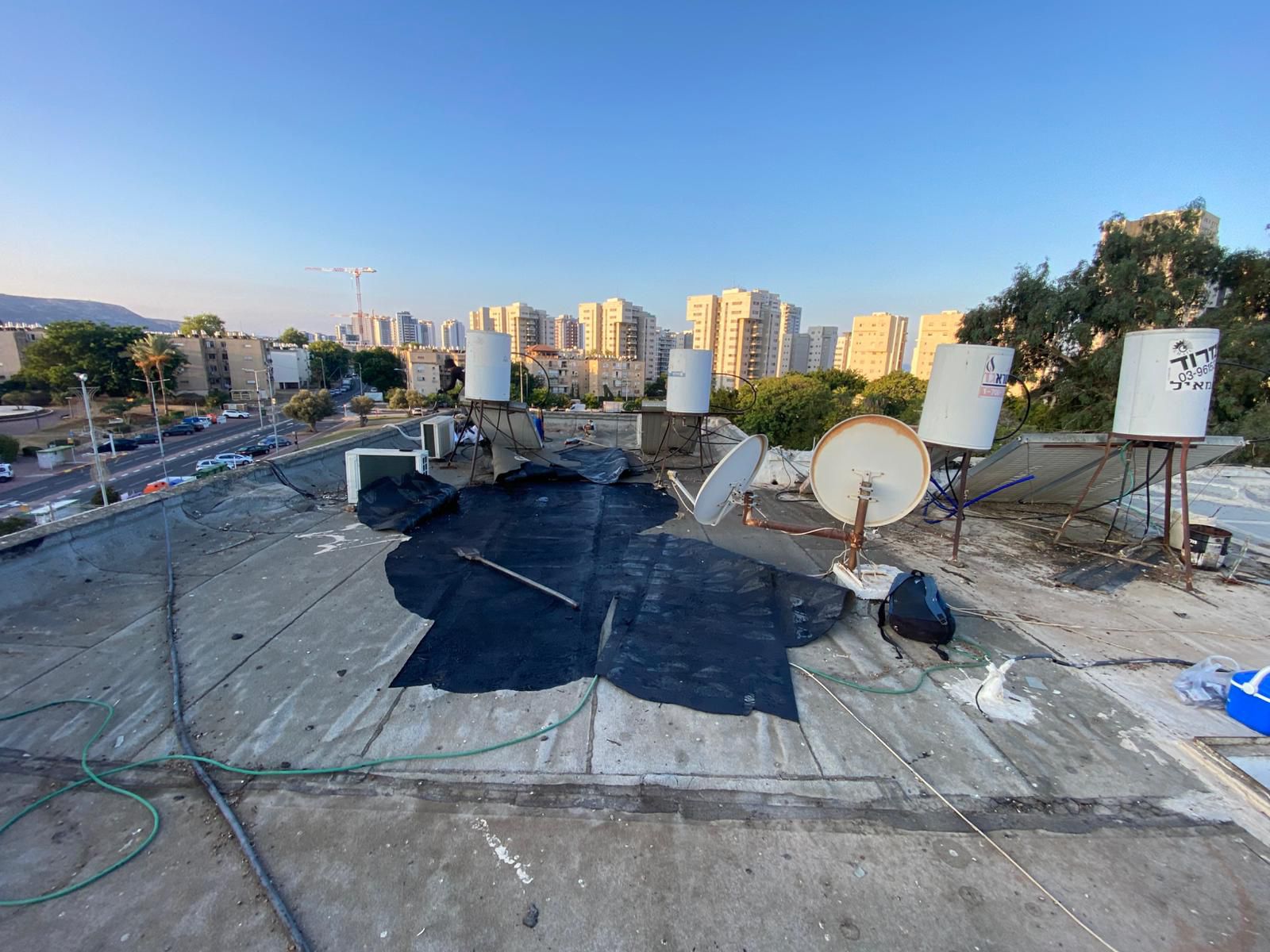 איטום גגות בטירת הכרמל – גג ישן עם יריעות מתקלפות ודודי שמש צפופים