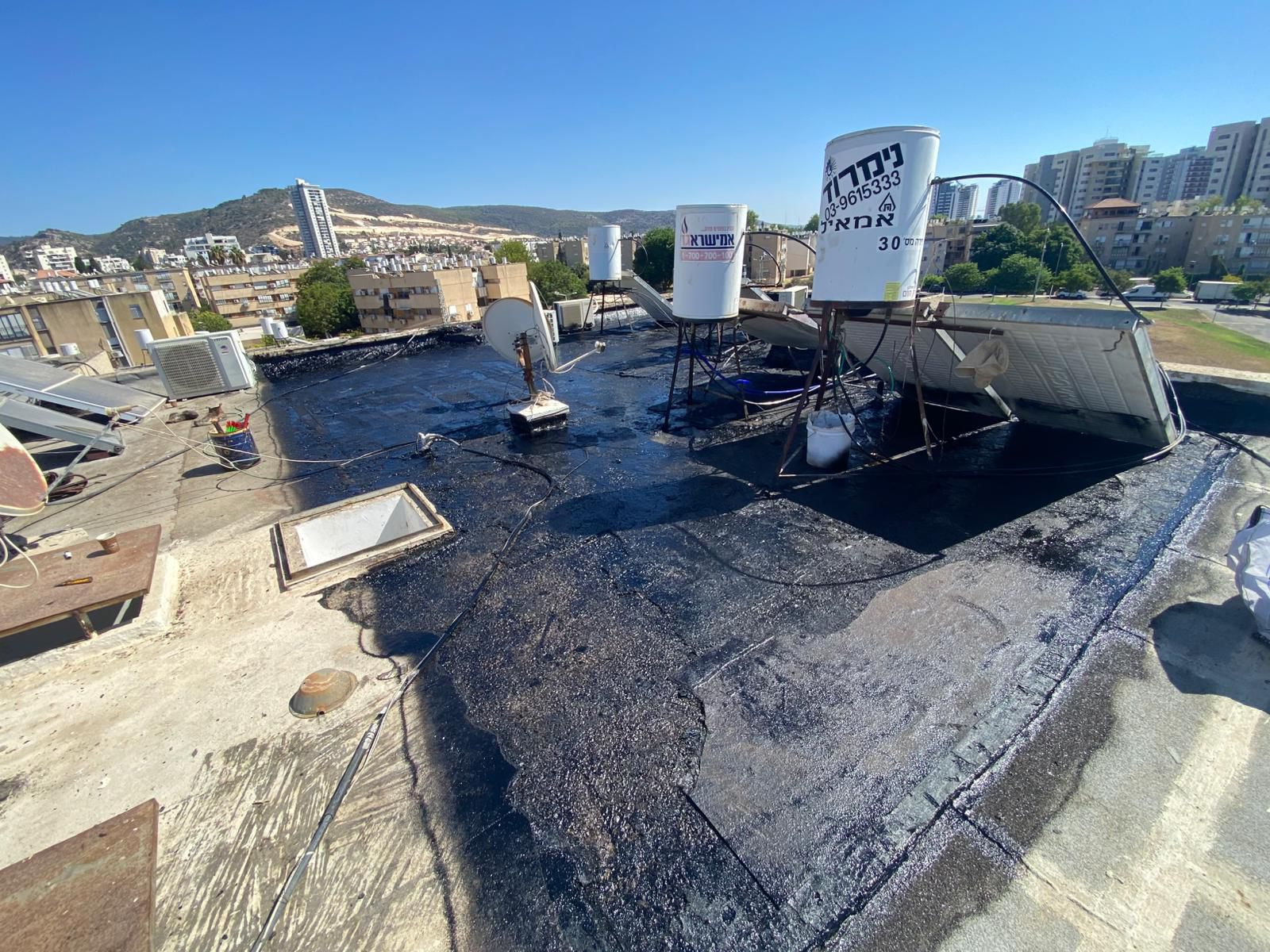 איטום גגות בטירת הכרמל – שכבת יסוד שחורה על הגג לפני יריעות ביטומניות