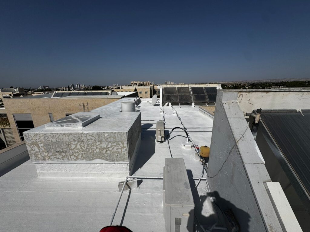 איטום גגות במודיעין עם שכבה ראשונה של אקרילפז על יריעות ביטומניות קיימות, כולל עיבוד מקצועי סביב קולטי שמש ופתחים בגג.