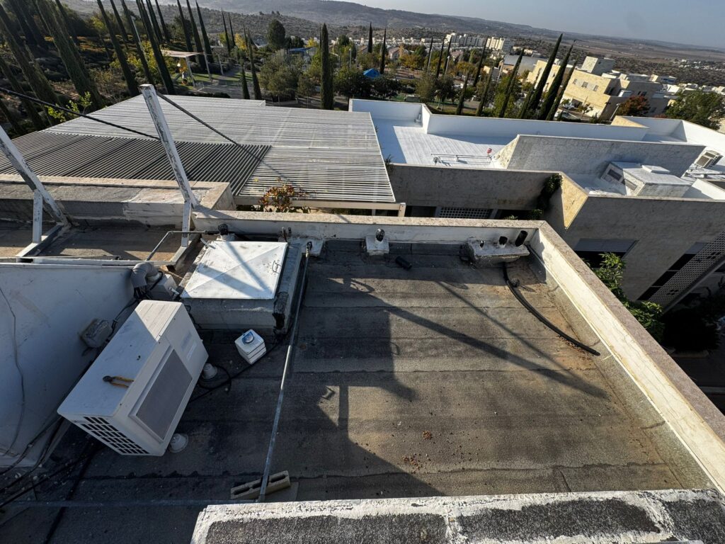 איטום גגות במודיעין לפני תחילת העבודה – גג עם יריעות ביטומניות ישנות לפני ציפוי באקרילפז.