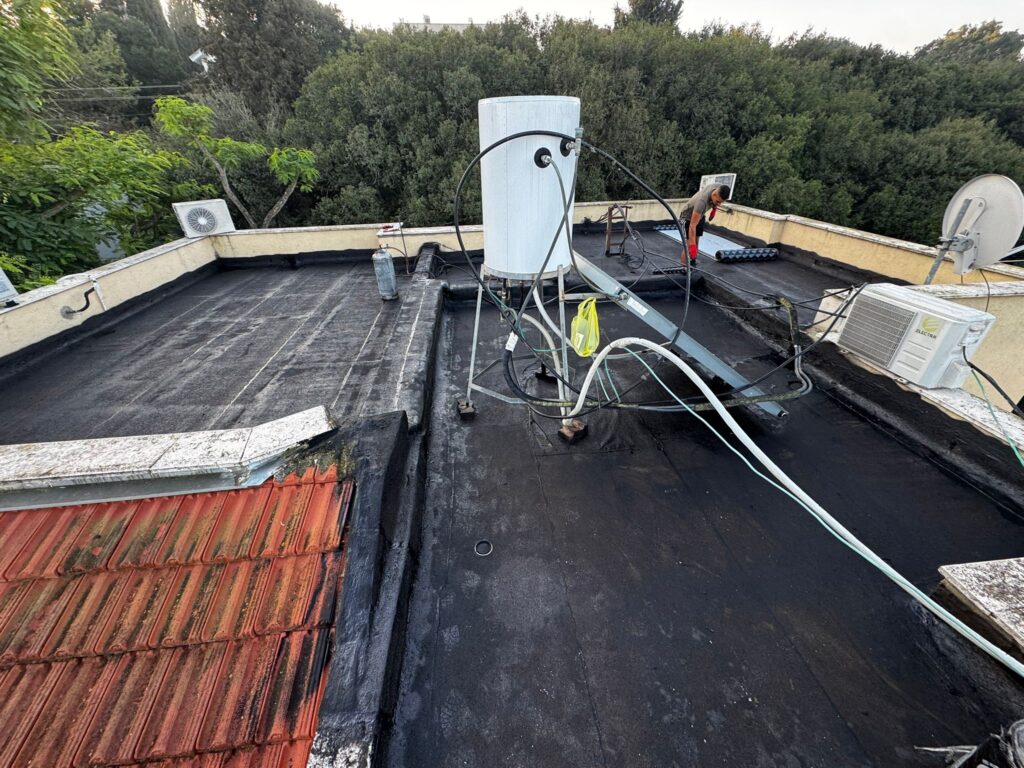 איטום גגות בתמרת – מריחת שכבת יסוד ביטומנית על הגג לפני התקנת היריעות