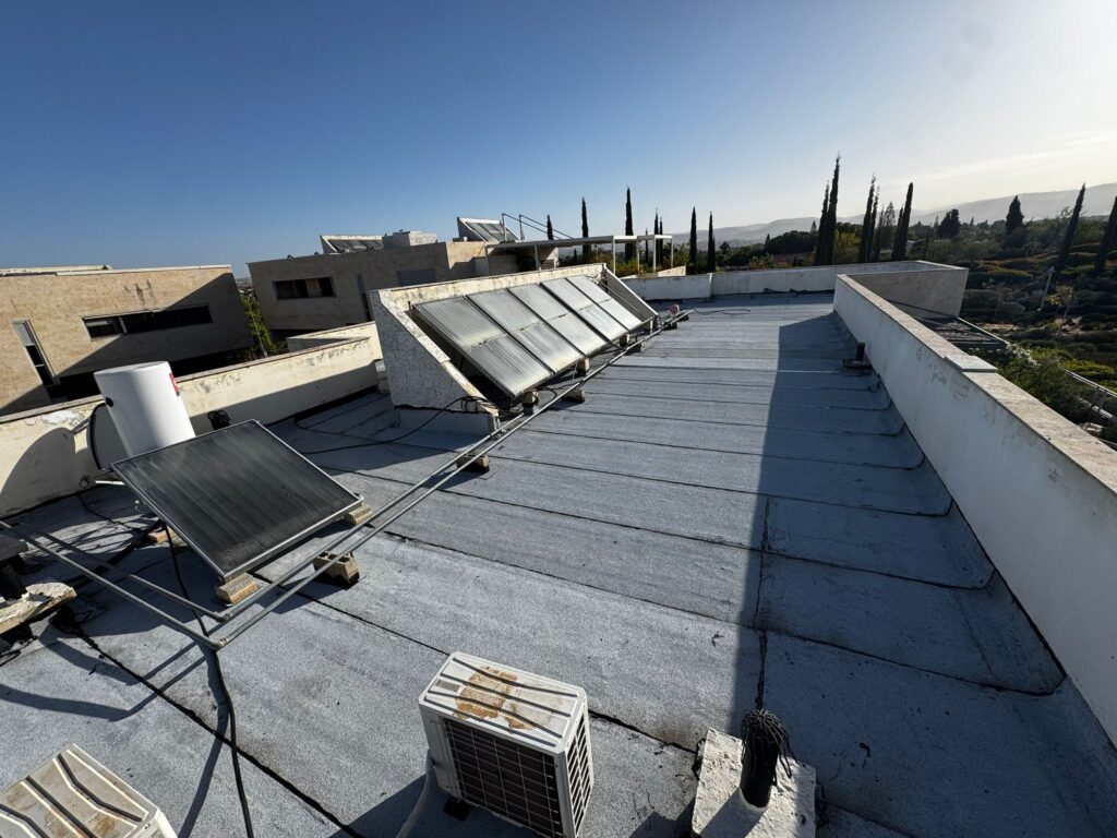 גג שטוח לאחר איטום גגות ביריעות ביטומניות מודיעין, כולל אזור דודי שמש ומתקני גג