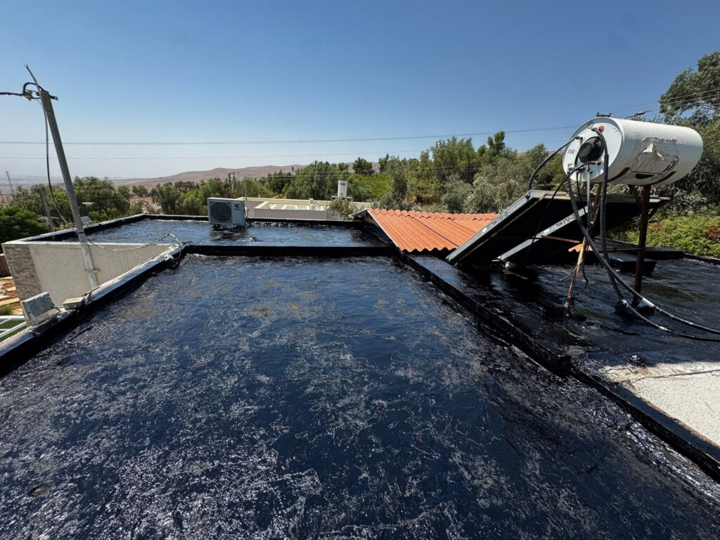 איטום גגות במעלה אפריים: קילוף האיטום הישן והנחת יריעות ביטומניות 1 שכבת ביטומן על הגג במעלה אפריים אחרי קילוף האיטום הישן, על רקע נוף בקעת הירדן