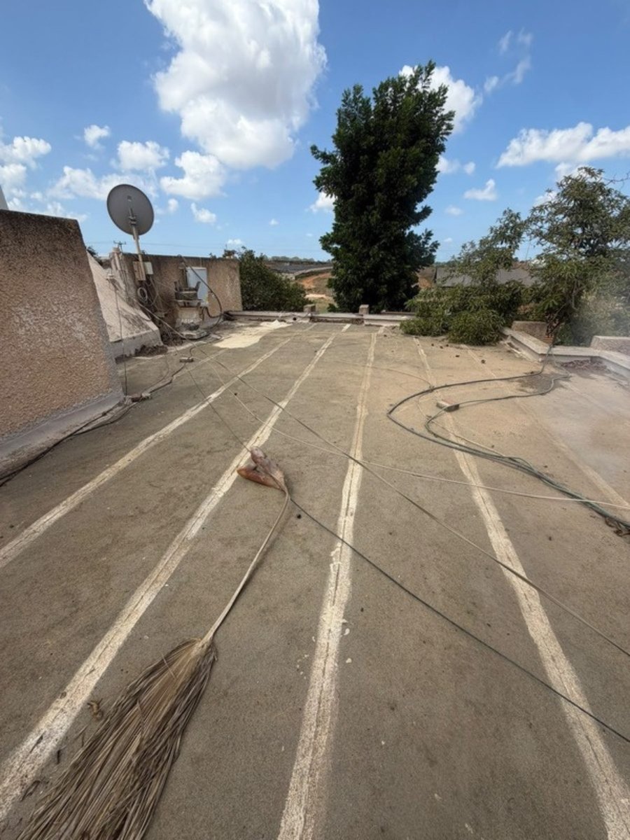 גג בכפר יעבץ לפני איטום: שכבות ביטומן ישנות עם תפרים סדוקים גג בכפר יעבץ לפני איטום: שכבות ביטומן ישנות עם תפרים סדוקים